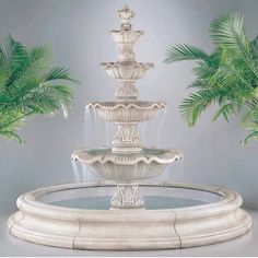 a white fountain with three fountains and palm trees in the backgrounnds