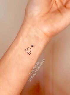 a person's arm with a small tattoo on it that says i love you