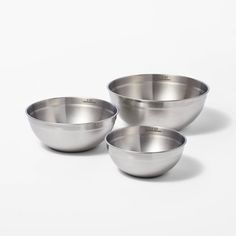 three stainless steel bowls sitting next to each other