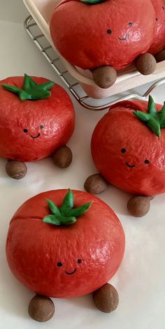 three red tomatoes with faces on them sitting in front of a white basket filled with chocolate chips