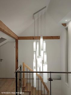 an empty room with some stairs and lights hanging from it's ceiling above them