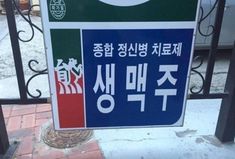 a sign that is on the side of a fence with writing in english and korean