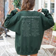 the back of a woman's green sweatshirt with poem printed on it and white writing