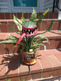 a plant that is sitting on the steps in front of a house with its mouth open