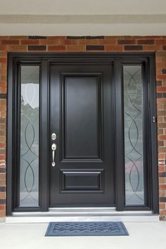 a black front door with glass panels and an entry mat on the outside of it