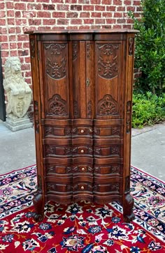 an old wooden armoire sitting on top of a rug next to a brick wall