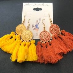 Introducing a stunning pair of quadruple tassel earrings that will add the perfect touch of flair to your accessory collection. These earrings are designed with four vibrant tassels suspended elegantly from a gorgeous gold-toned accented medallion, creating a statement piece that’s both stylish and playful. Whether you’re looking to elevate your casual look or add a fun twist to your evening wear, these earrings are sure to impress. This set comes with two color options, allowing you to switch u Gold Bohemian Earrings With Fringe, Bohemian Gold Fringe Earrings, Bohemian Yellow Earrings With Latkans, Bohemian Gold Tassel Earrings With Fringe, Gold Bohemian Tassel Earrings With Fringe, Adjustable Gold Tassel Earrings With Fringe, Orange Tassel Earrings, Adjustable Gold Bohemian Tassel Earrings, Orange Tassel Dangle Earrings