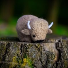 a small stuffed animal sitting on top of a tree stump