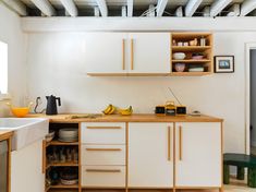 a kitchen with white cabinets and wooden counter tops