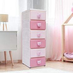 a white and pink dresser with four drawers in a child's room next to a doll house