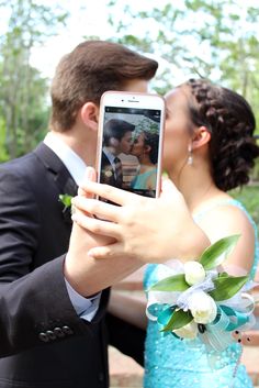 a man and woman taking a photo with their cell phone