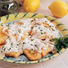 some food is on a plate with lemons and other items in the back ground