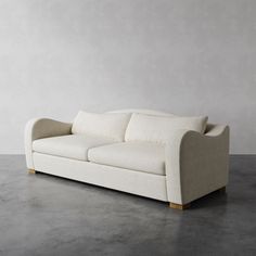 a white couch sitting on top of a cement floor