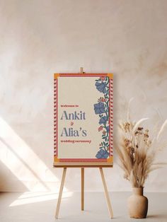 an easel next to a vase with dried grass in it and a sign that says, akiti ali's wedding ceremony