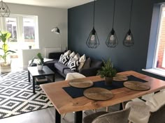 a living room filled with furniture and a wooden table in front of a large window