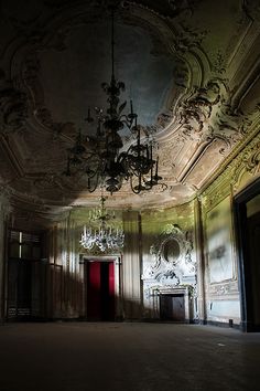 an empty room with chandelier and door