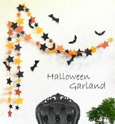 a chair sitting in front of a wall with bats on it and the words halloween garland