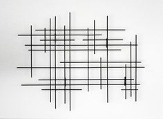 a piece of art that is made out of black and white lines on a wall