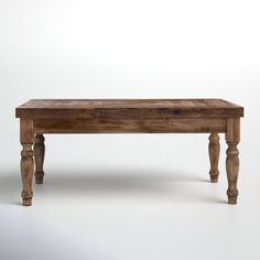 an old wooden table with turned legs on a plain white background in front of the camera