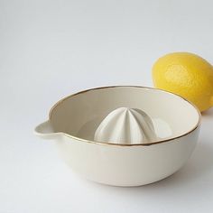 a white bowl with a yellow lemon next to it