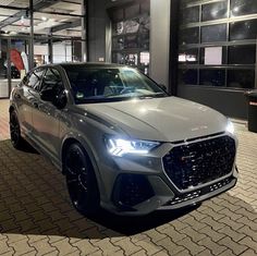 a silver car parked in front of a building