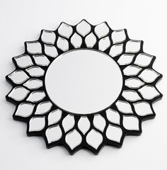 a mirror that is on the wall in front of a white background with black accents