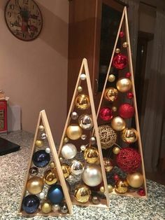 two christmas trees made out of wood and decorated with gold, silver and red ornaments