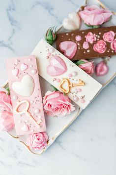 two plates with cookies decorated like keys and flowers on them, one is pink and the other is brown