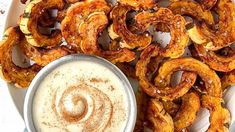 some onion rings on a plate with a dipping sauce