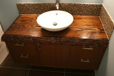 a bathroom sink sitting on top of a wooden counter