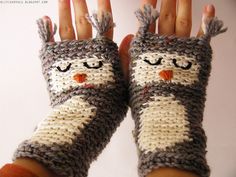 two hands wearing knitted mittens with eyes and nose