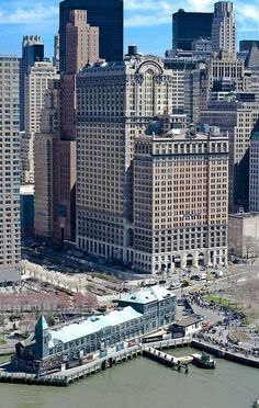 an aerial view of a city with tall buildings and boats in the water near it