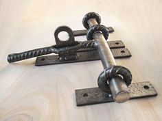 three metal chains are attached to each other on a wooden surface with wood grain in the background