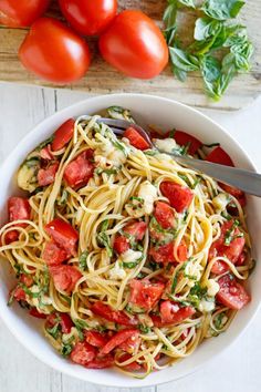 a white bowl filled with pasta and tomatoes