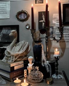 a table topped with books and candles on top of it