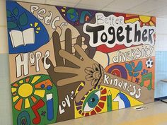 a large mural in the hallway of a school with hands and words painted on it