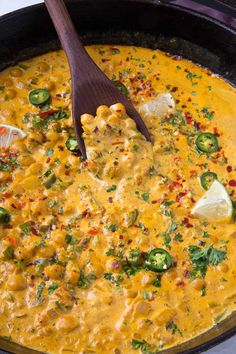 a skillet filled with yellow sauce and green peppers, topped with tortilla chips