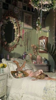 a woman laying on a bed in a room with lots of hanging plants and mirrors