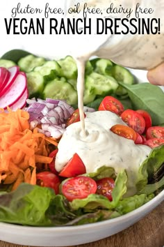 a person pouring ranch dressing on a salad with lettuce, tomatoes and cucumbers