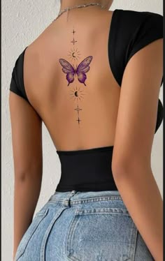 the back of a woman's body with a butterfly tattoo on her lower back