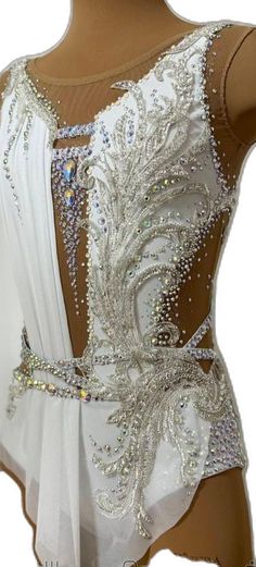 the back of a woman's white dress with sequins and beads on it