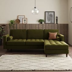 a green couch sitting on top of a white rug in a living room next to a wooden wall