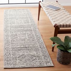 a white rug sitting on top of a hard wood floor next to a wooden bench