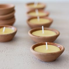 small wooden bowls filled with candles on top of a table