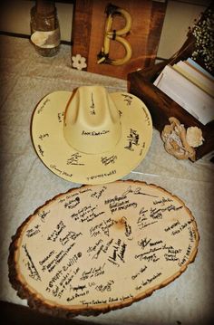 two hats are sitting on a table with writing all over them, and one has a cowboy's hat