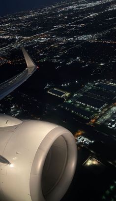 an airplane wing flying over the city lights at night