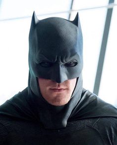 a man in a batman costume looking at the camera