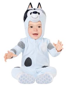 a baby in a costume sitting on the ground with his hands out and eyes closed