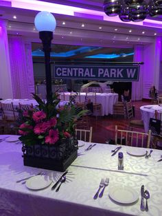 the center table is set up for a formal event with purple lighting and floral centerpieces