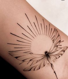 a woman's thigh with a tattoo design on the back of her leg and sunburst